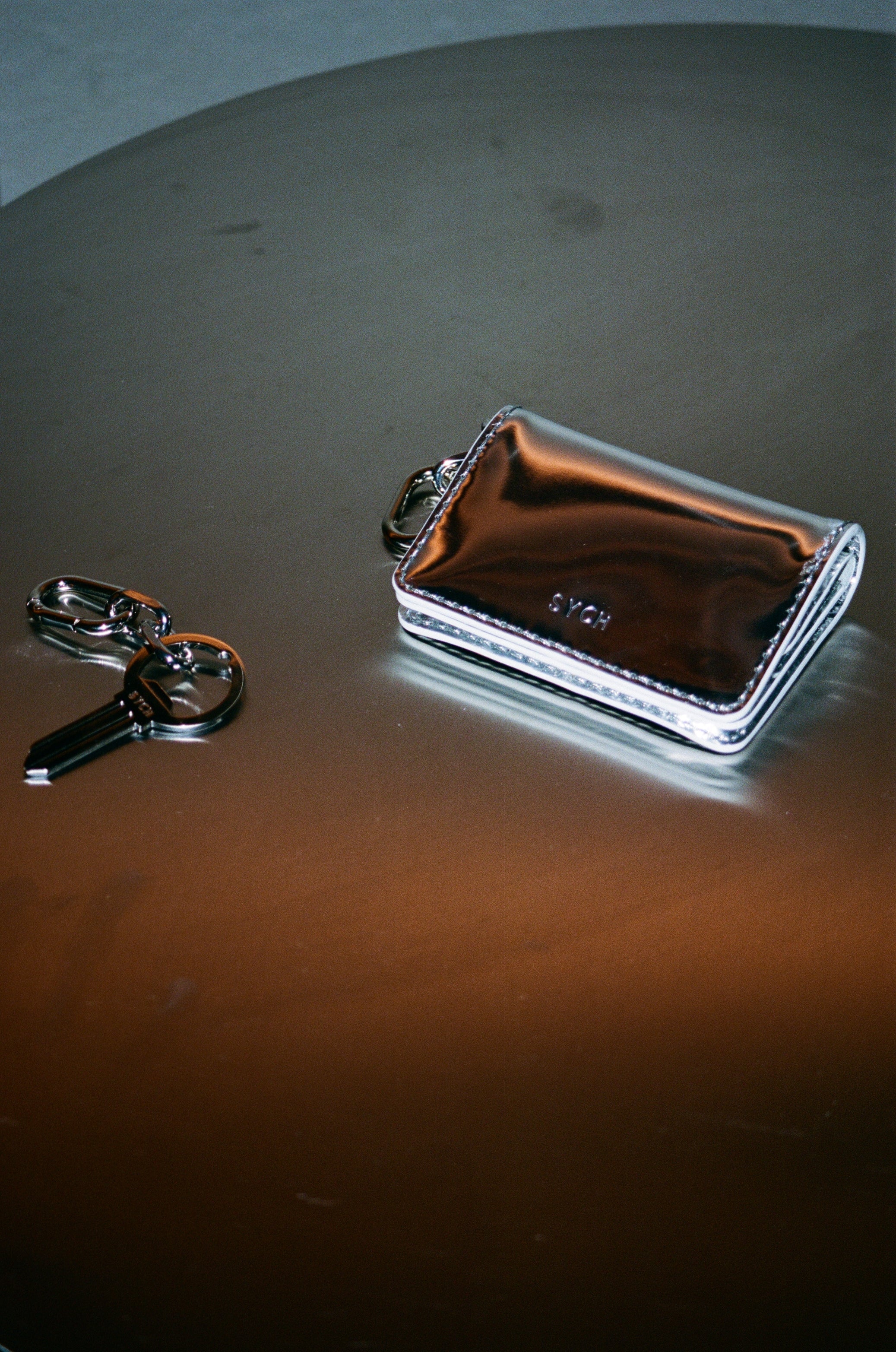 Sych silver bottle opener keyring in the shape of a key with a chain and silver tobacco pouch