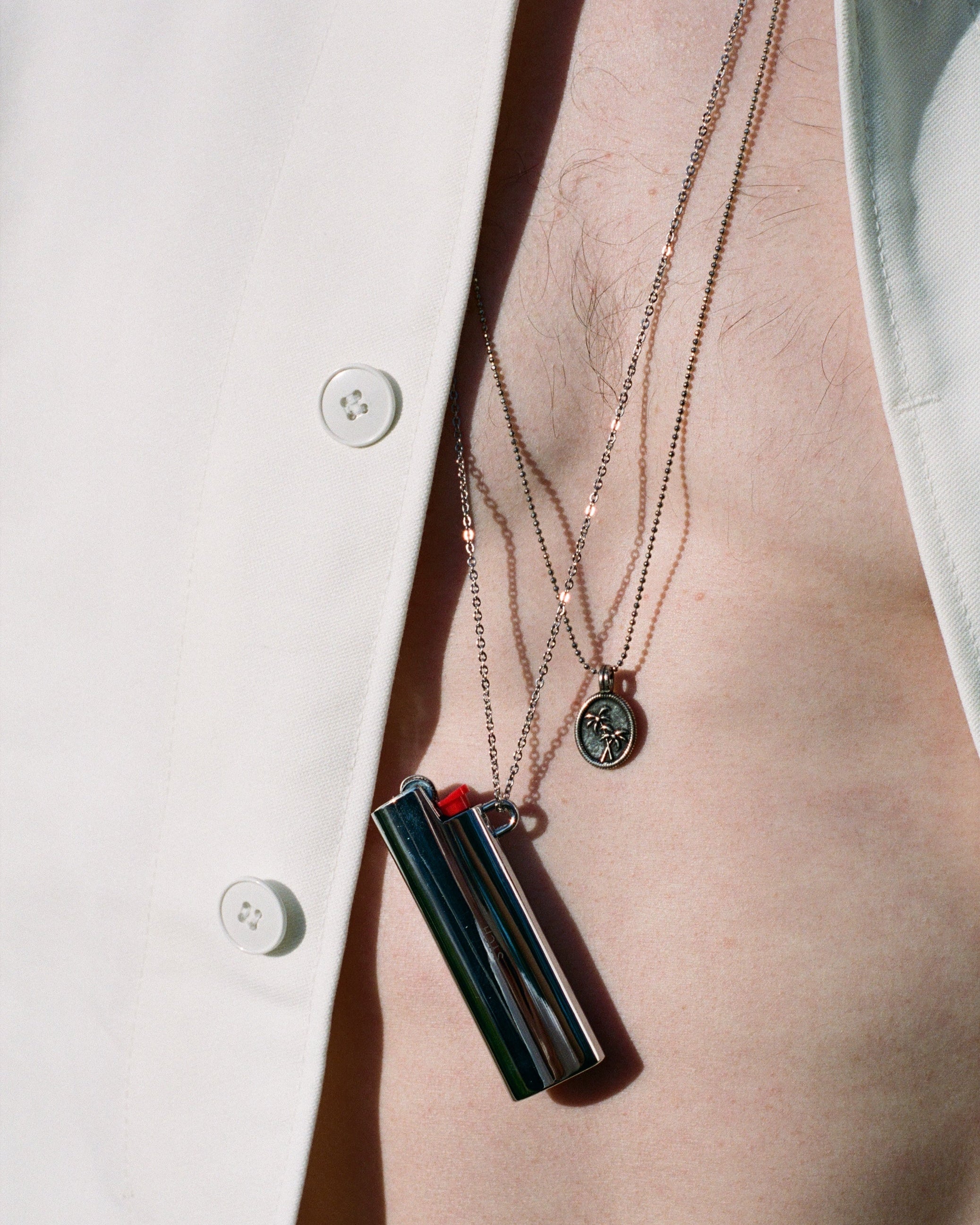 Silver metal lighter case necklace close-up, Bic J23 holder